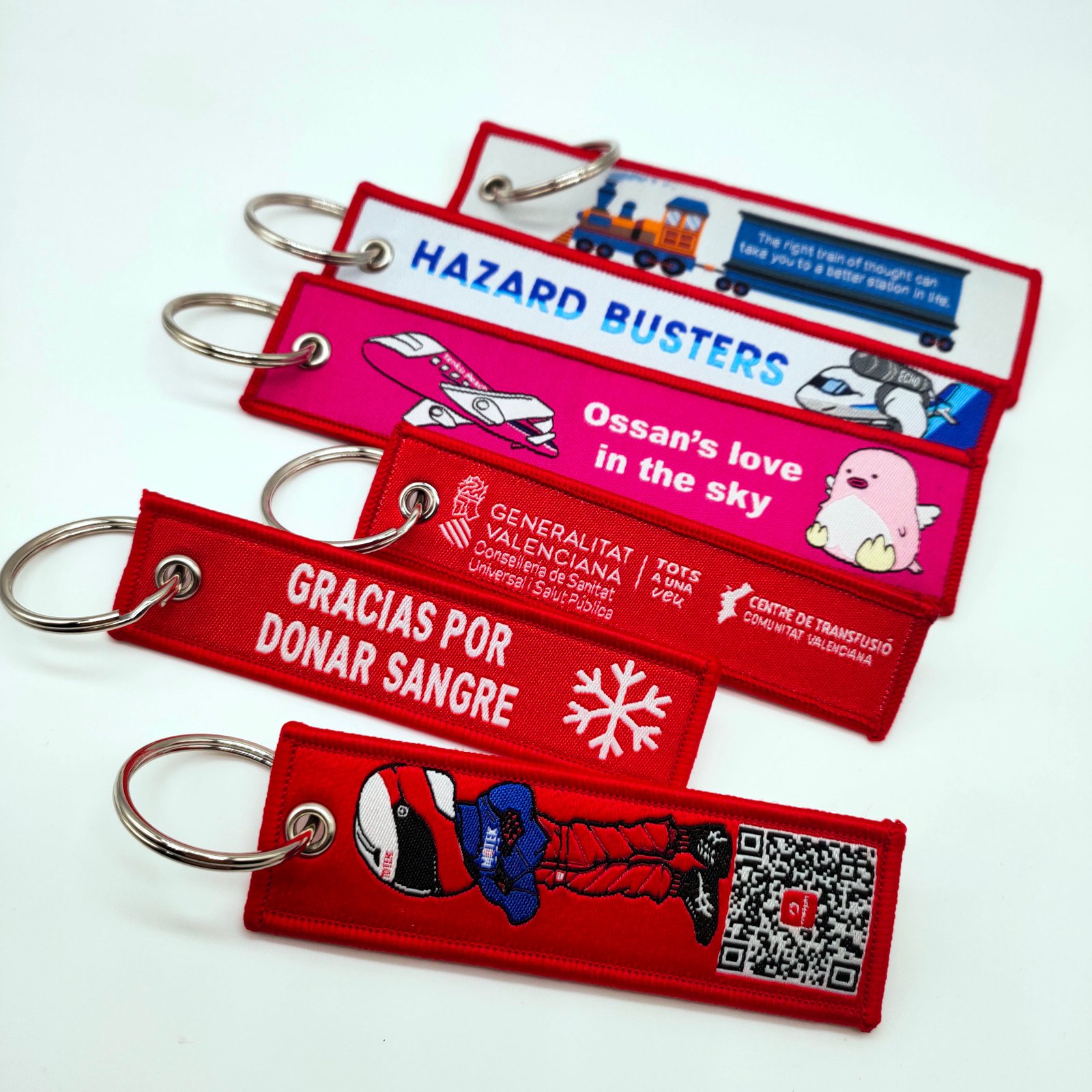 "Red woven keychains with hazard safety and donation messages"