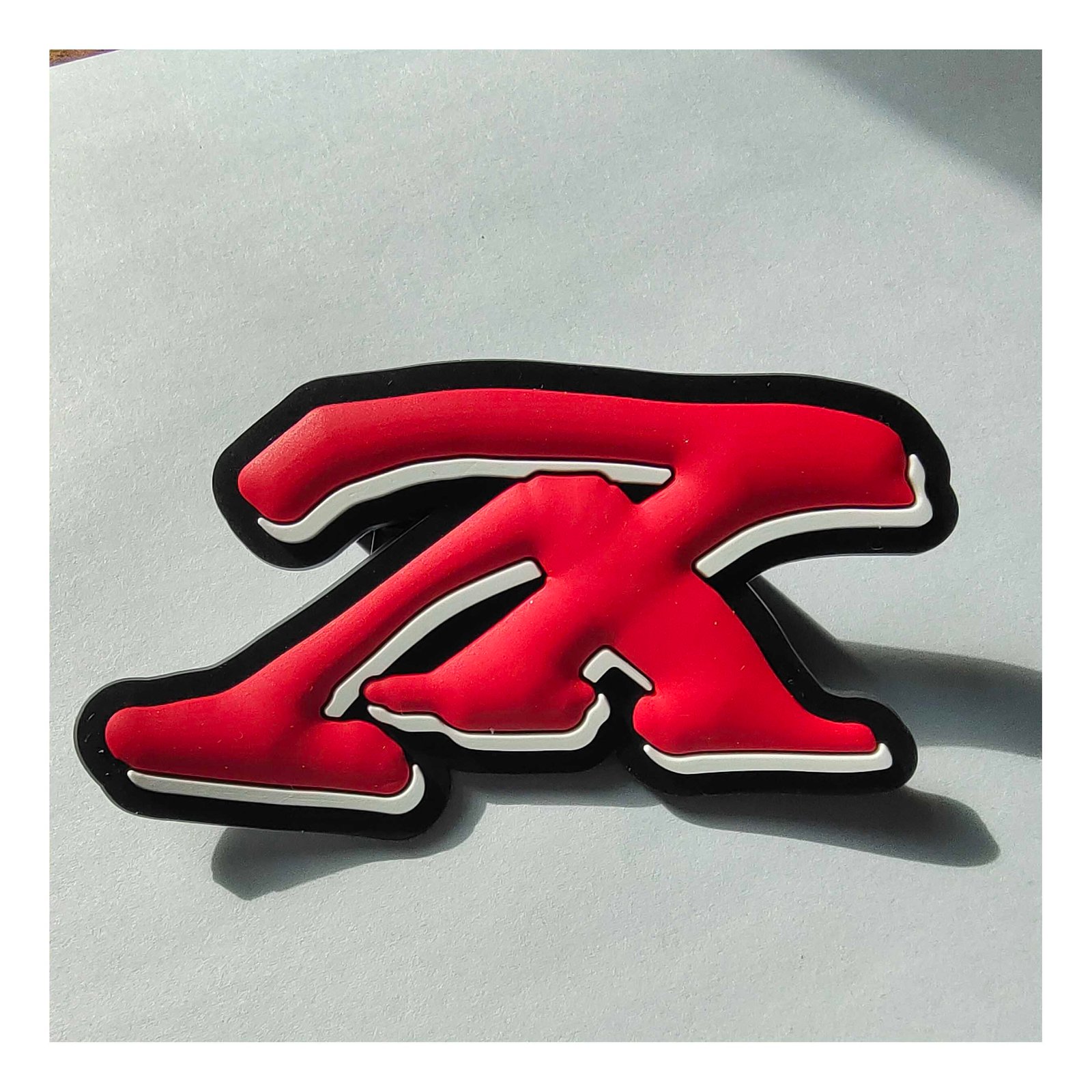 Custom red and white PVC patch with bold "X" letter design