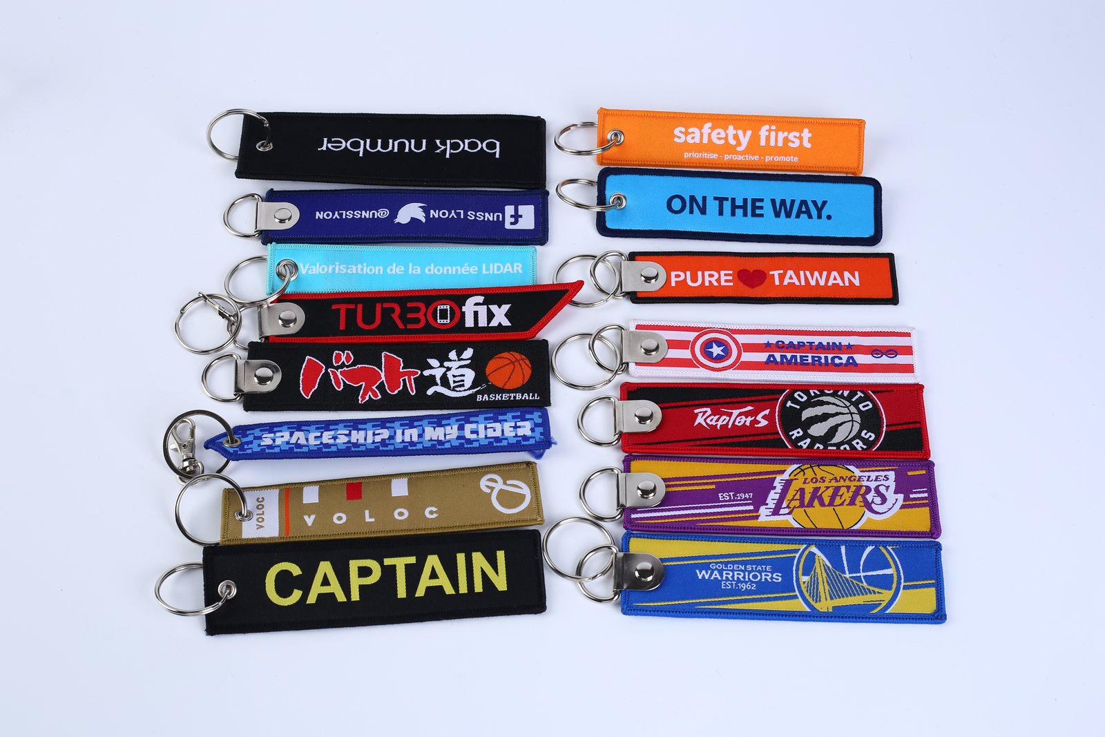 "Assorted promotional woven keychains with logos and safety messages"