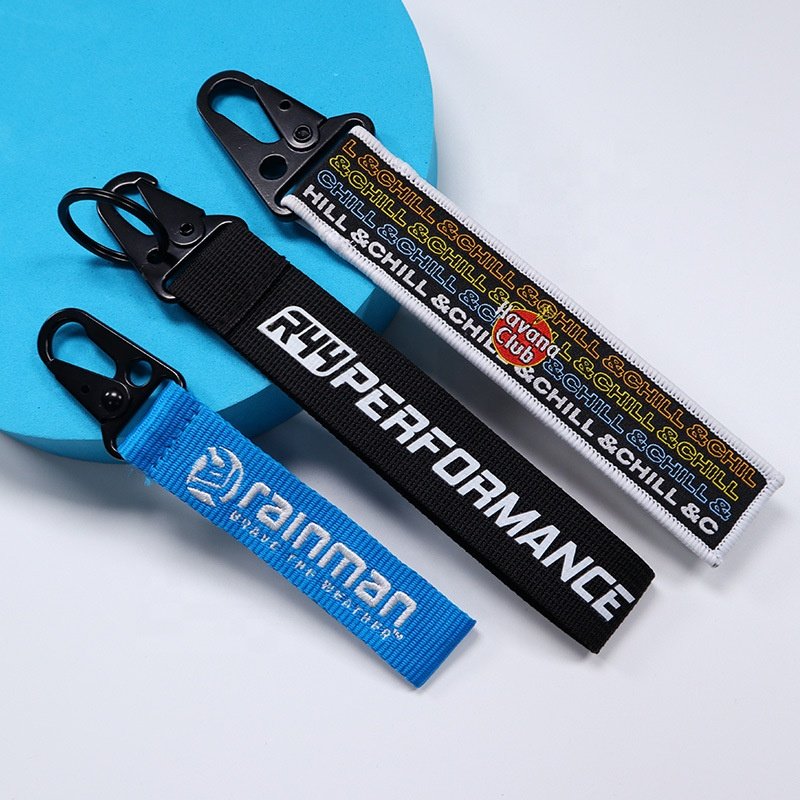 "Set of three custom lanyard keychains with logos and black metal clips"